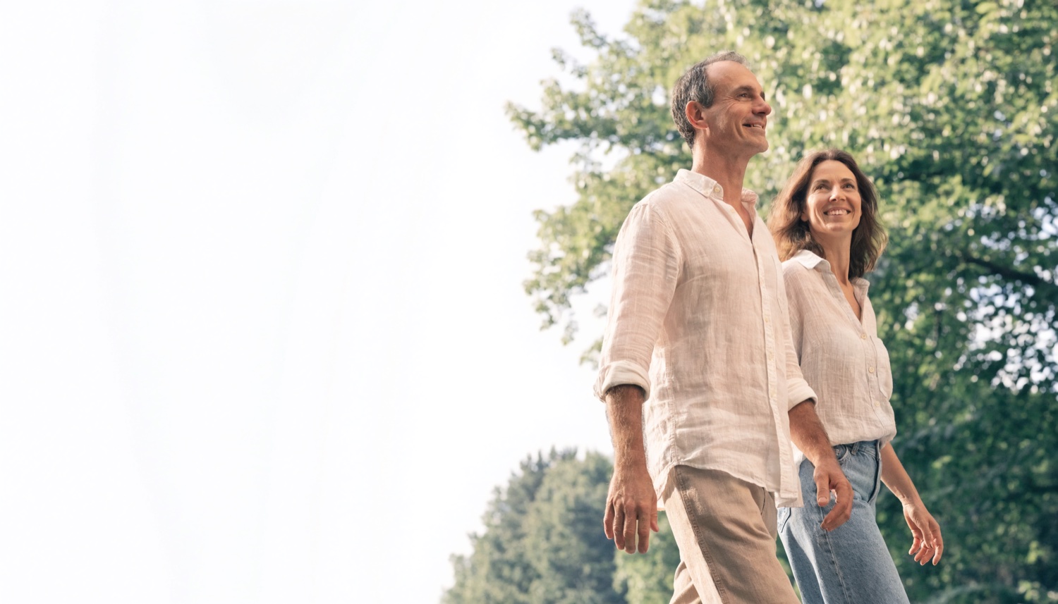 A man and a woman walking together outdoors in morning light